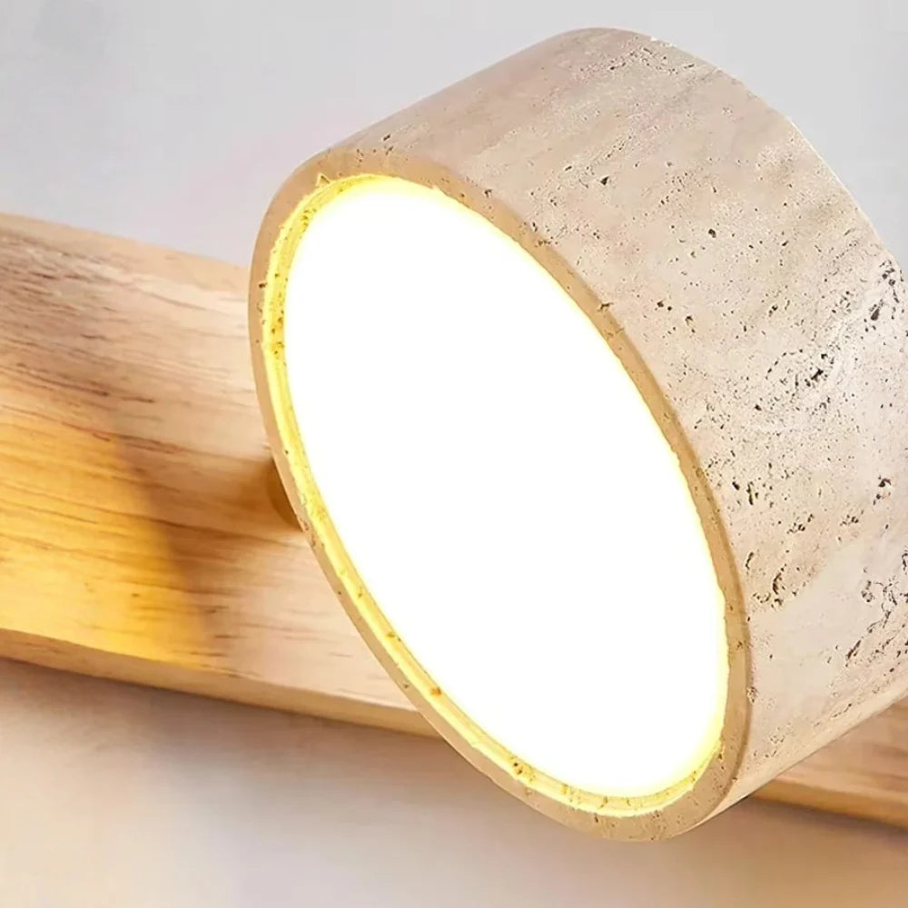 Notu travertine wall light close-up of a lit travertine spotlight showing its warm LED lens