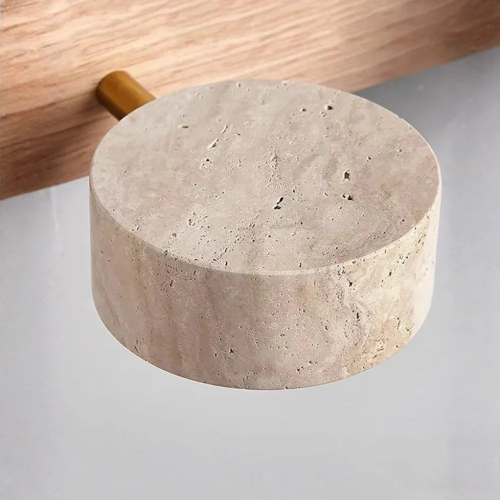 Notu travertine wall light close-up of a natural travertine spotlight puck on the light wood bar