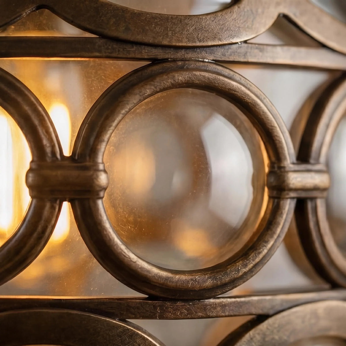 Detail of the Olly pendant's bronze ring frame holding round clear glass lenses