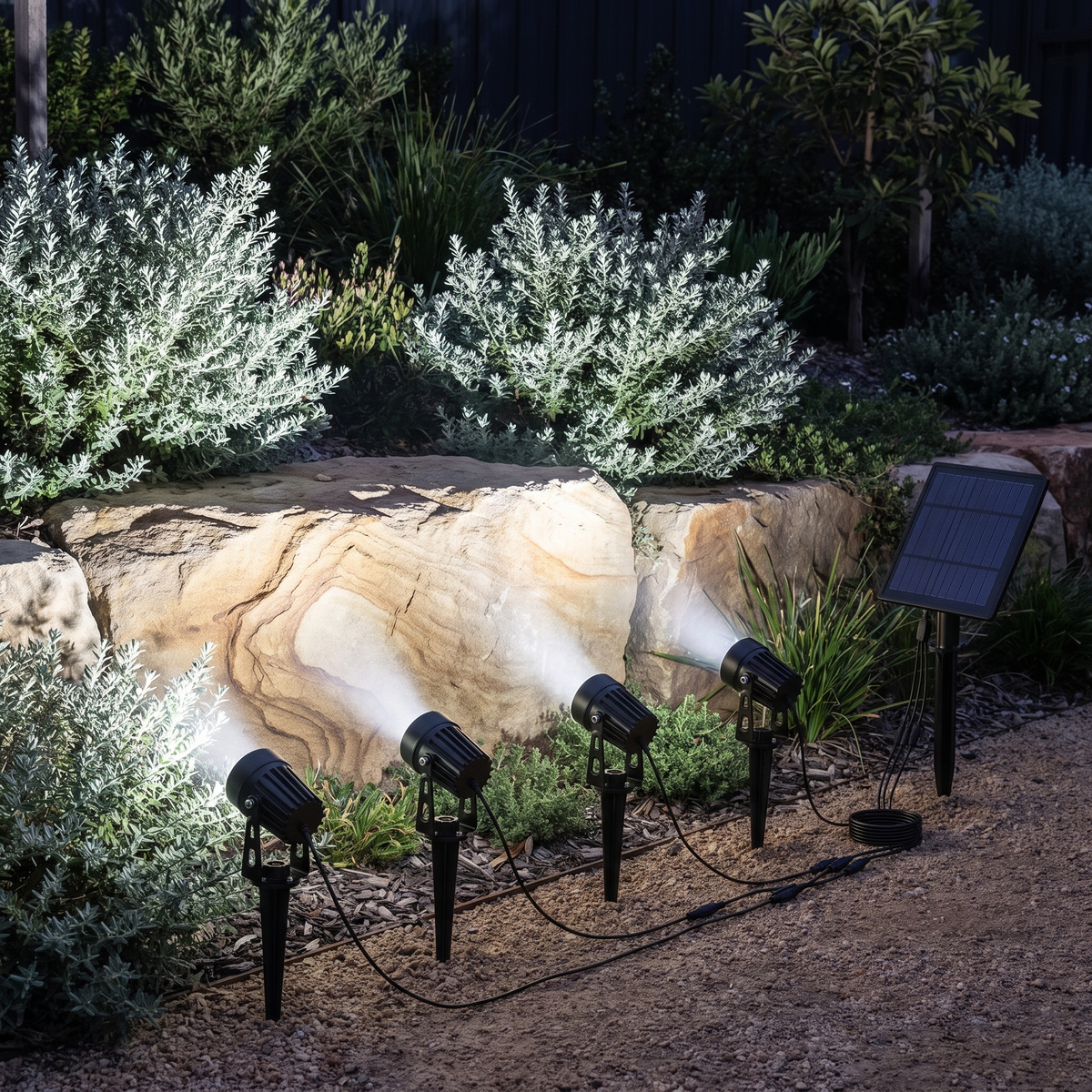 Oria cool white solar spotlights lighting a sandstone boulder wall