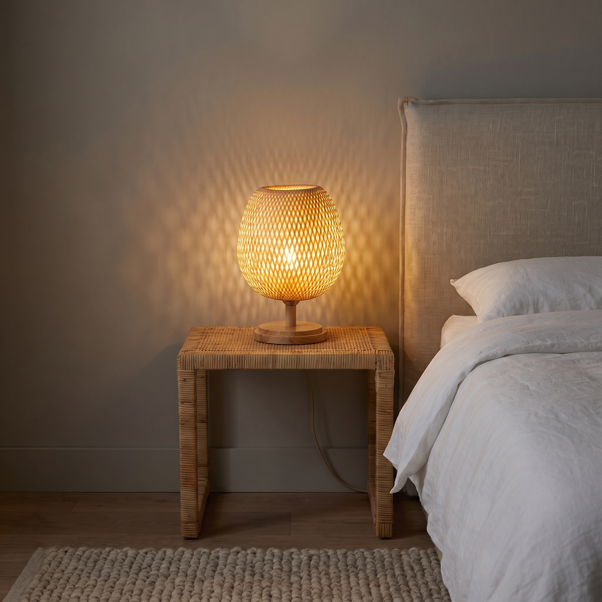 Sabatu bamboo table lamp short size with wood base lit on a rattan bedside table at night