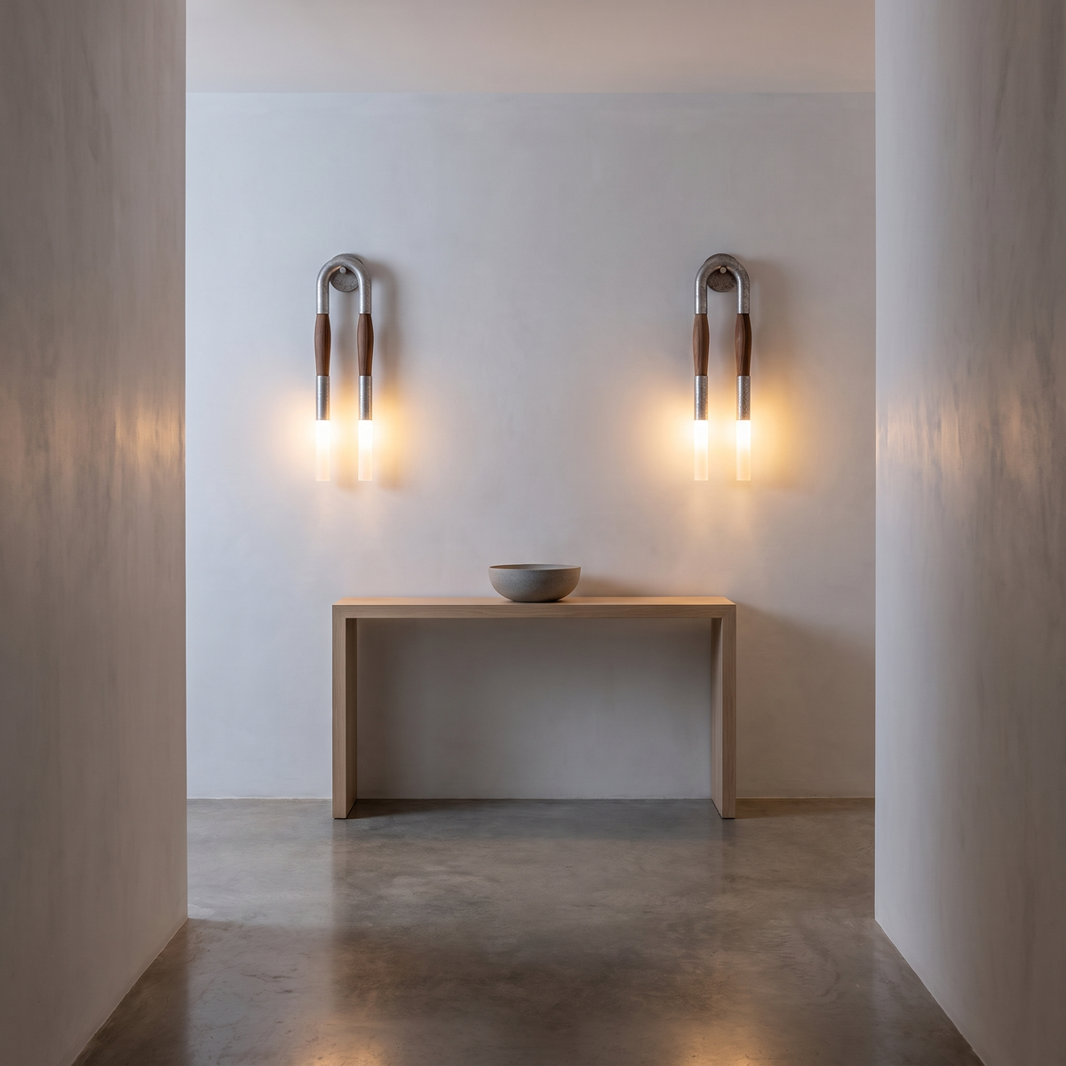 Pair of Salin nickel double wall sconces above a pale oak console