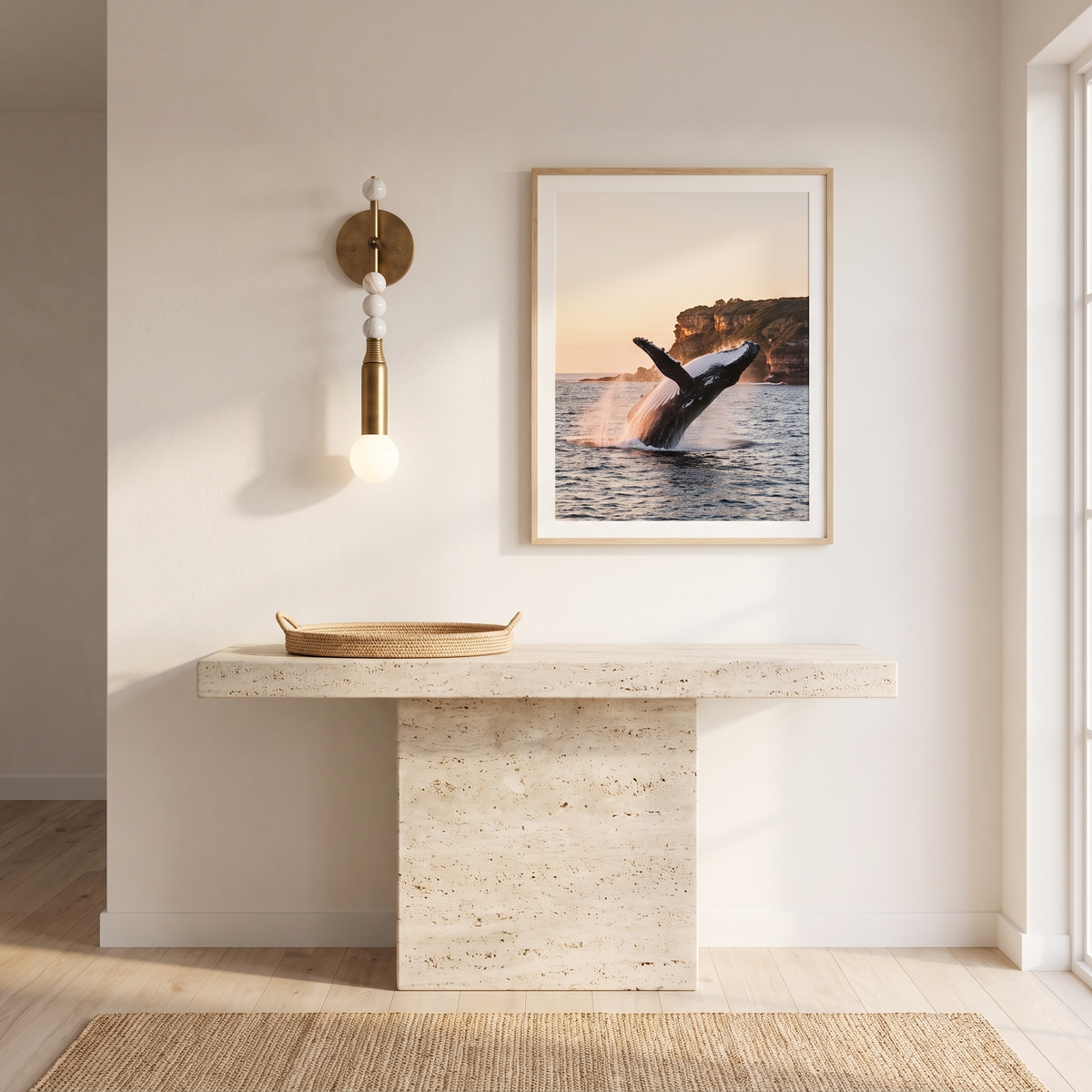 Sands brass and white marble wall sconce above a travertine console in a beach house entry