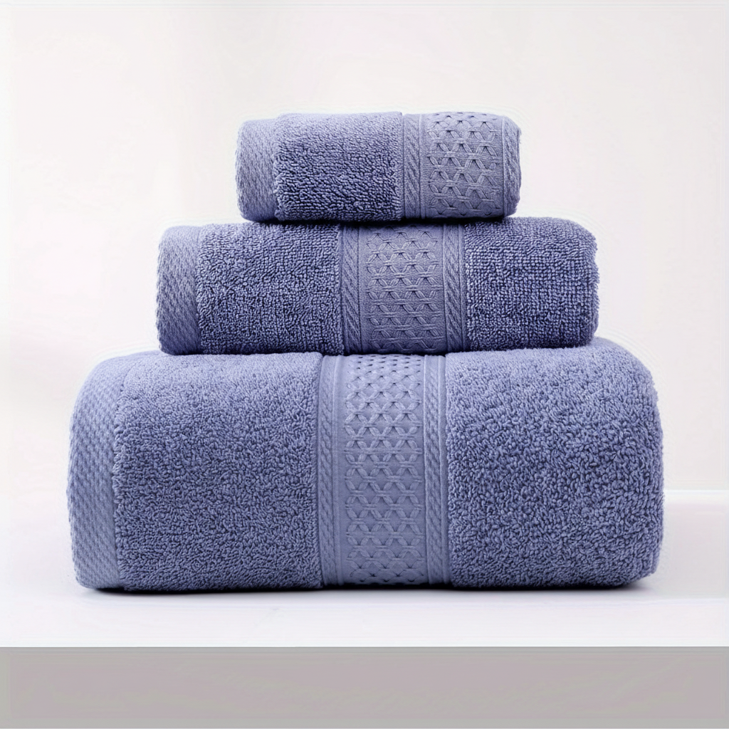 Serene 100% cotton bath towels in blue with a woven border stacked on a white background