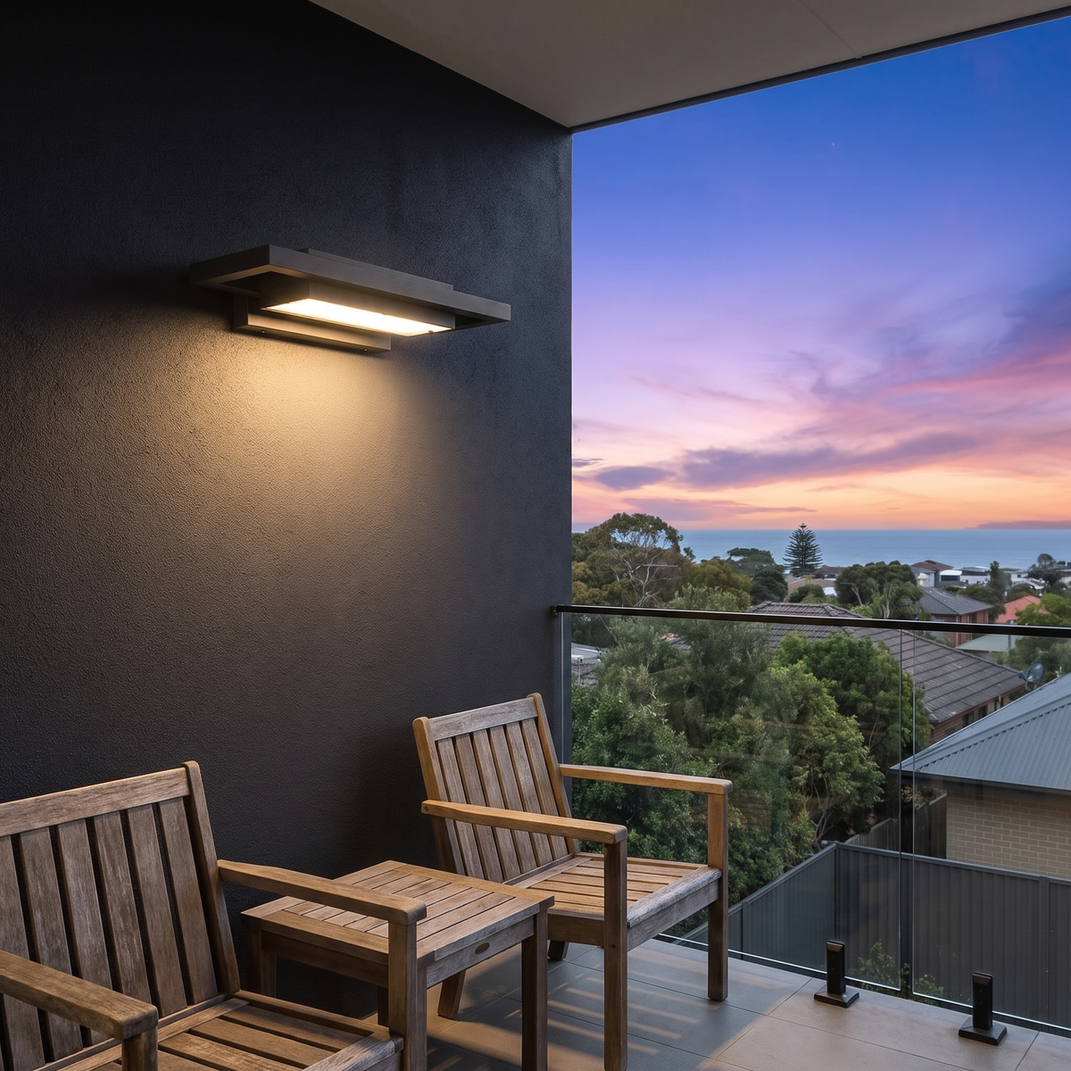 Shan outdoor wall light, 35cm, above timber chairs on a hillside balcony with ocean view at dusk