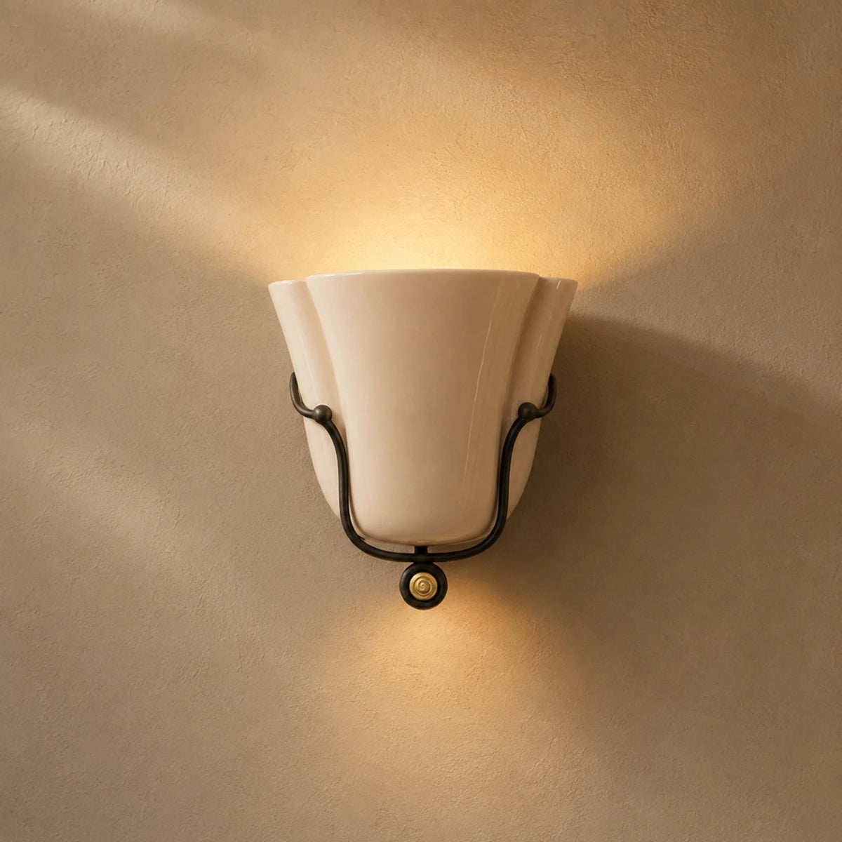 Smyth ceramic wall sconce in glossy beige glaze washing light up the wall