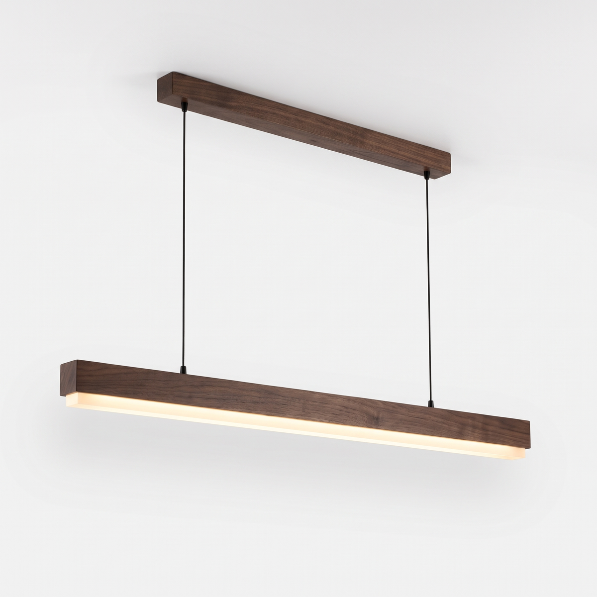 Sorrento linear timber pendant light in Walnut B with its matching ceiling rail, on a white background