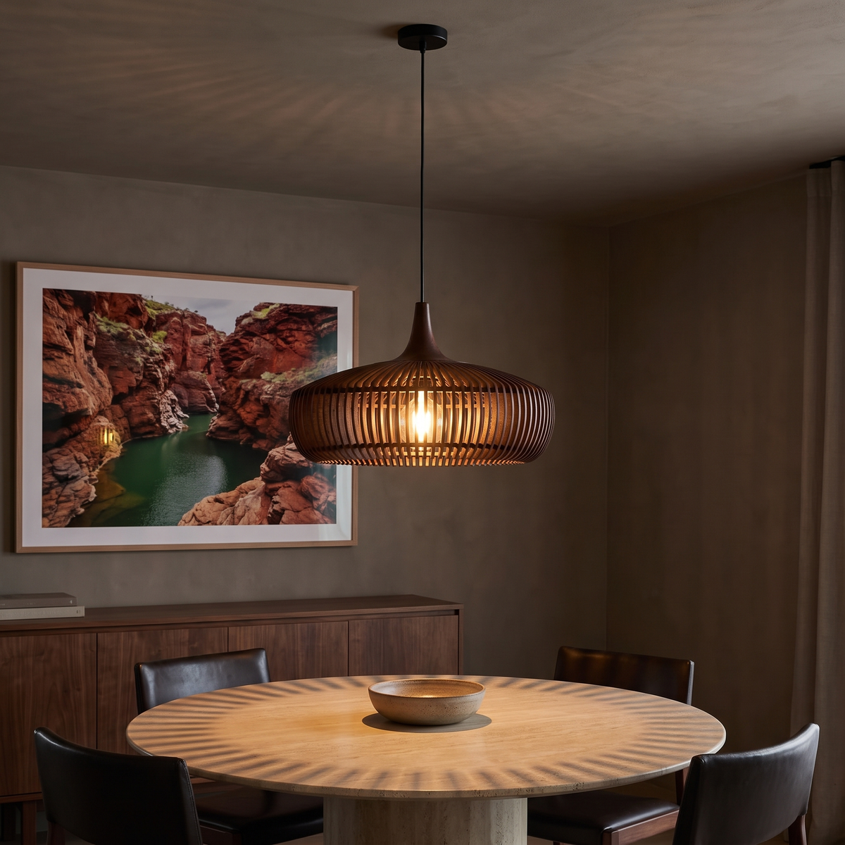 Walnut Talandji slatted wood pendant light over a round travertine dining table at dusk