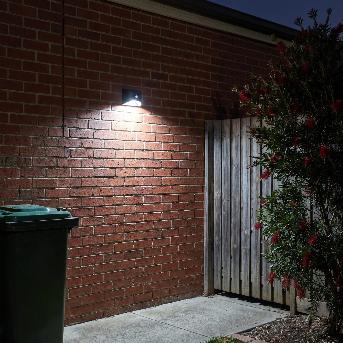 Tasi cool white solar motion sensor wall light on a brick wall by a side gate