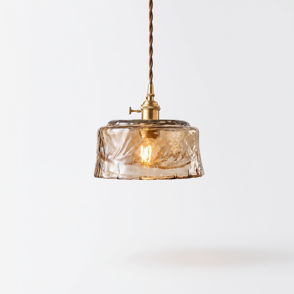 Tooky Model B amber glass drum pendant with brass lamp holder on a plain white background