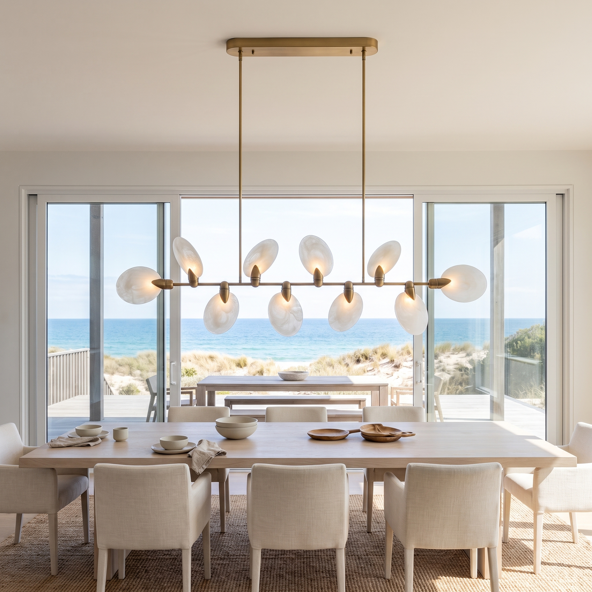 Vale modern chandelier above a white oak dining table in a beach house facing the ocean