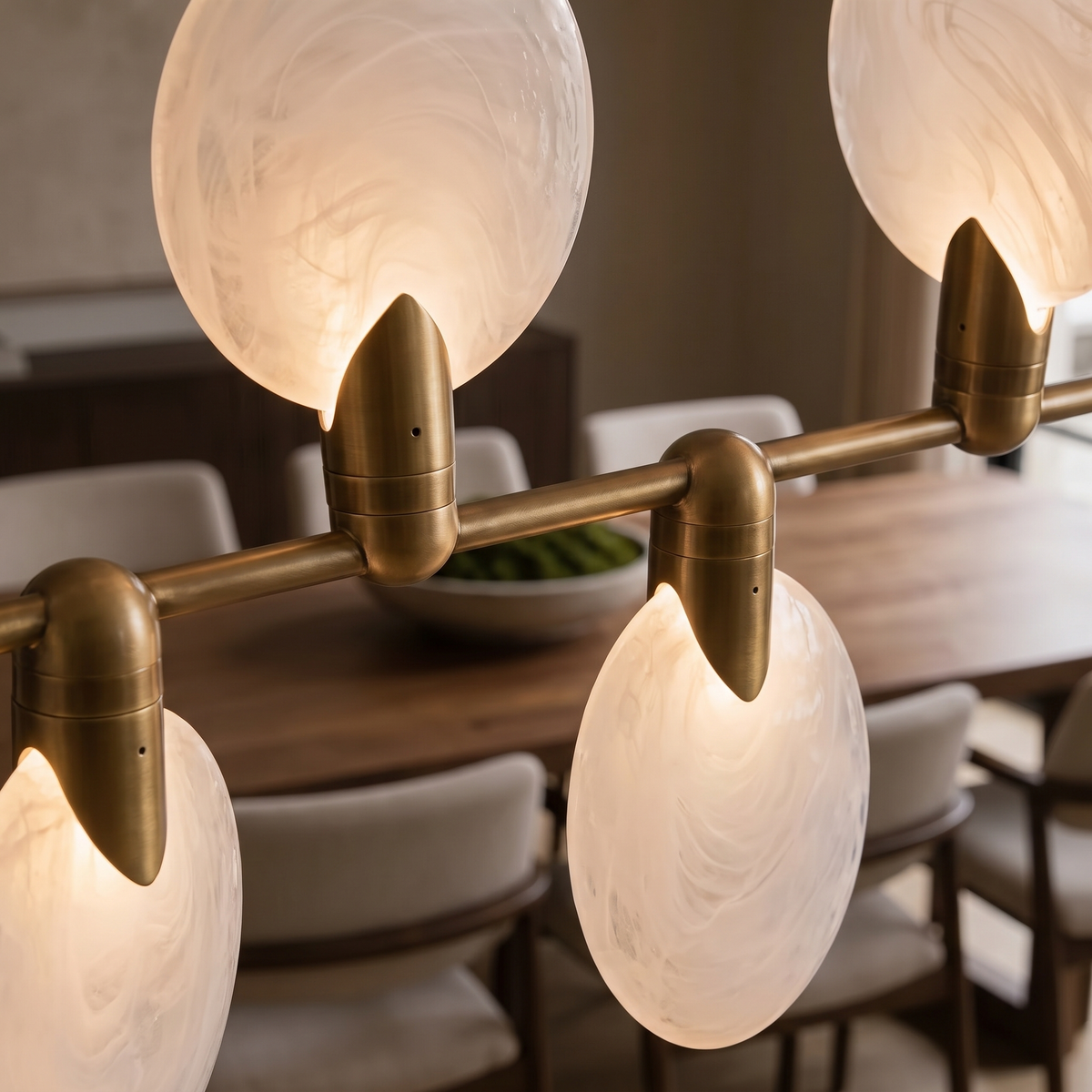 Vale modern chandelier close up of the glowing hand-blown glass discs on gold-finished caps