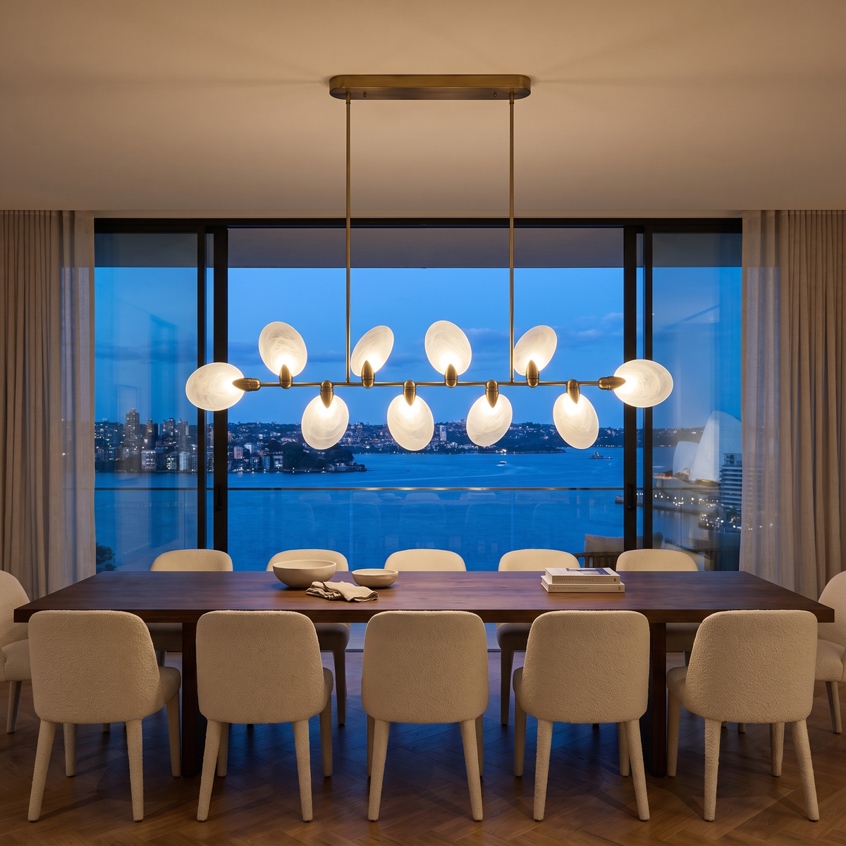 Vale modern chandelier centred along a long walnut dining table overlooking Sydney Harbour at dusk