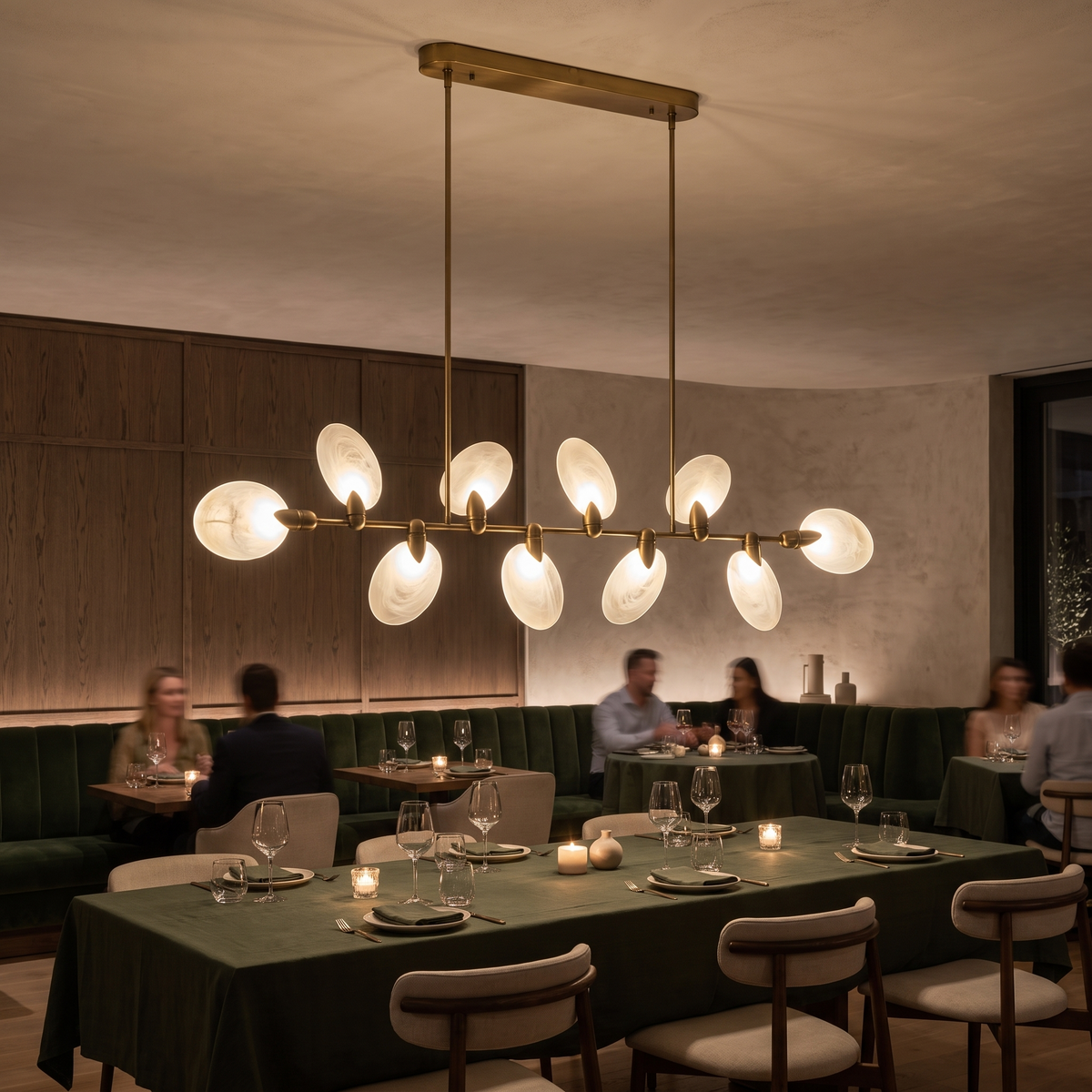 Vale modern chandelier glowing along a long dining table in an upscale restaurant at night