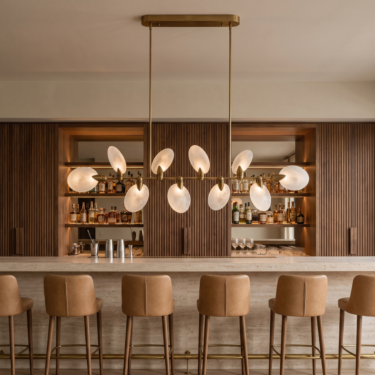 Vale modern chandelier running the length of a travertine bar in a hotel cocktail lounge