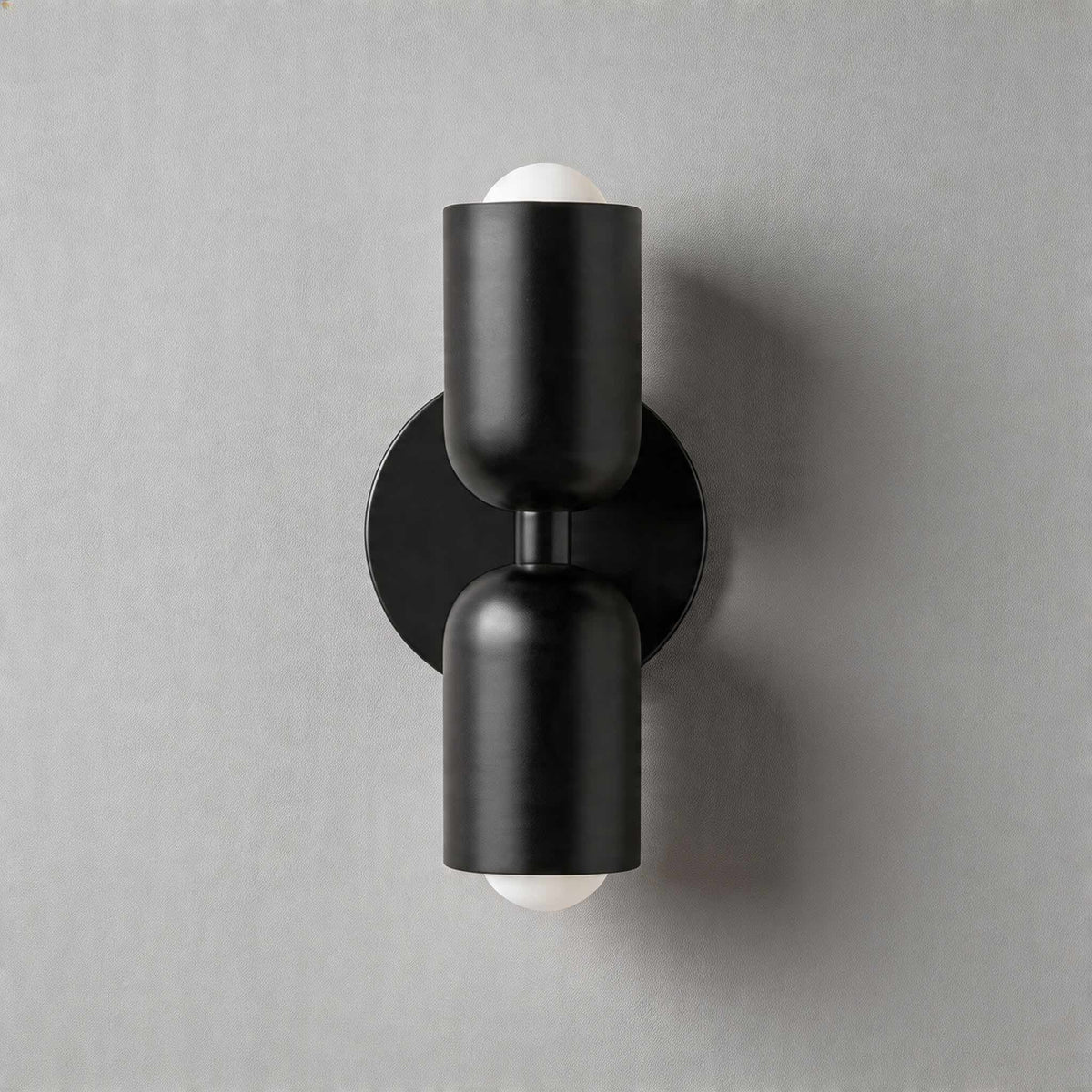 Vic Nordic up down wall sconce with a black wall plate and two black painted iron shades