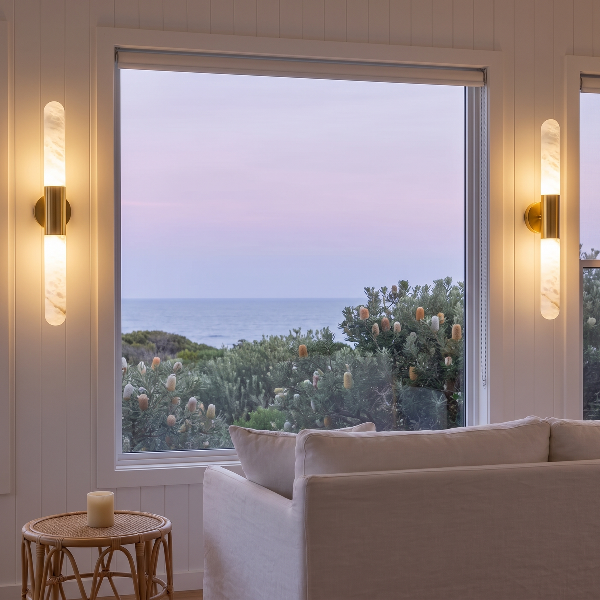 Pair of Waverly gold and alabaster wall lights flanking an ocean-view window