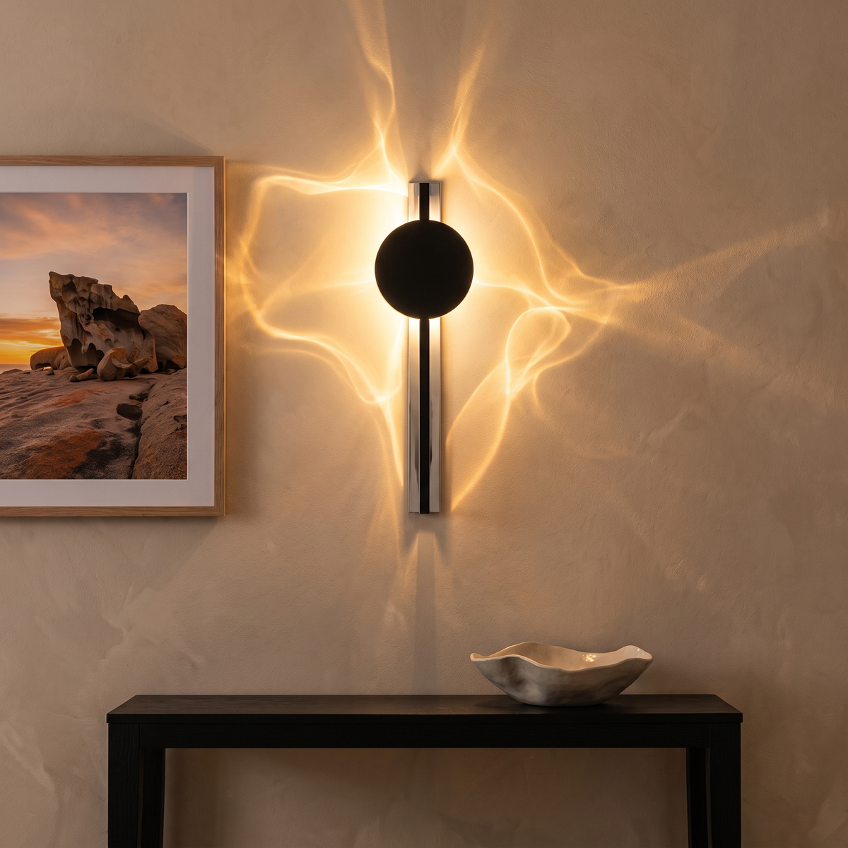 Alya sculptural wall sconce throwing rippling light above a black console in an entry