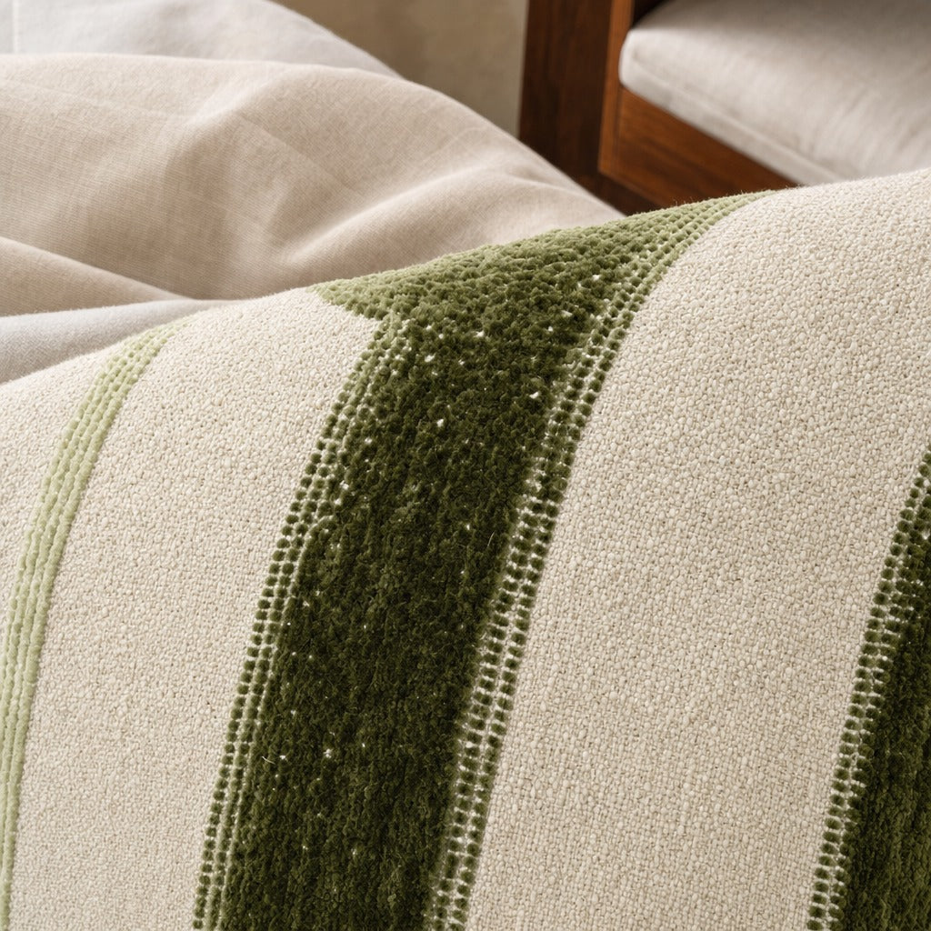 Banks striped linen and velvet throw pillow up close on a bed with natural linen bedding