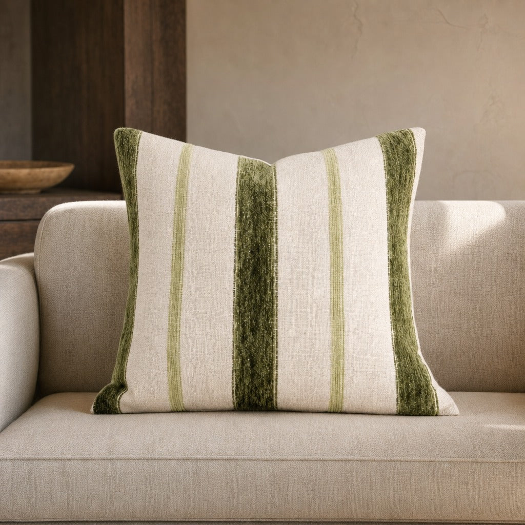 Banks striped linen and velvet throw pillow in earthy green on a cream linen sofa