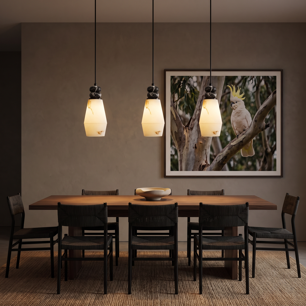 Three Banyjima Model D faceted faux alabaster pendants glowing over a walnut dining table