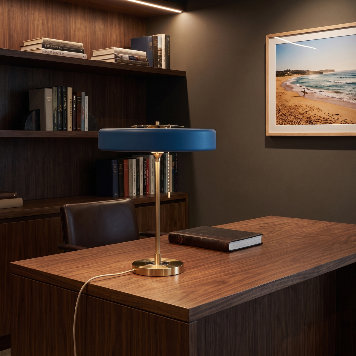 Baya minimalist table lamp in blue on a walnut desk in a home study