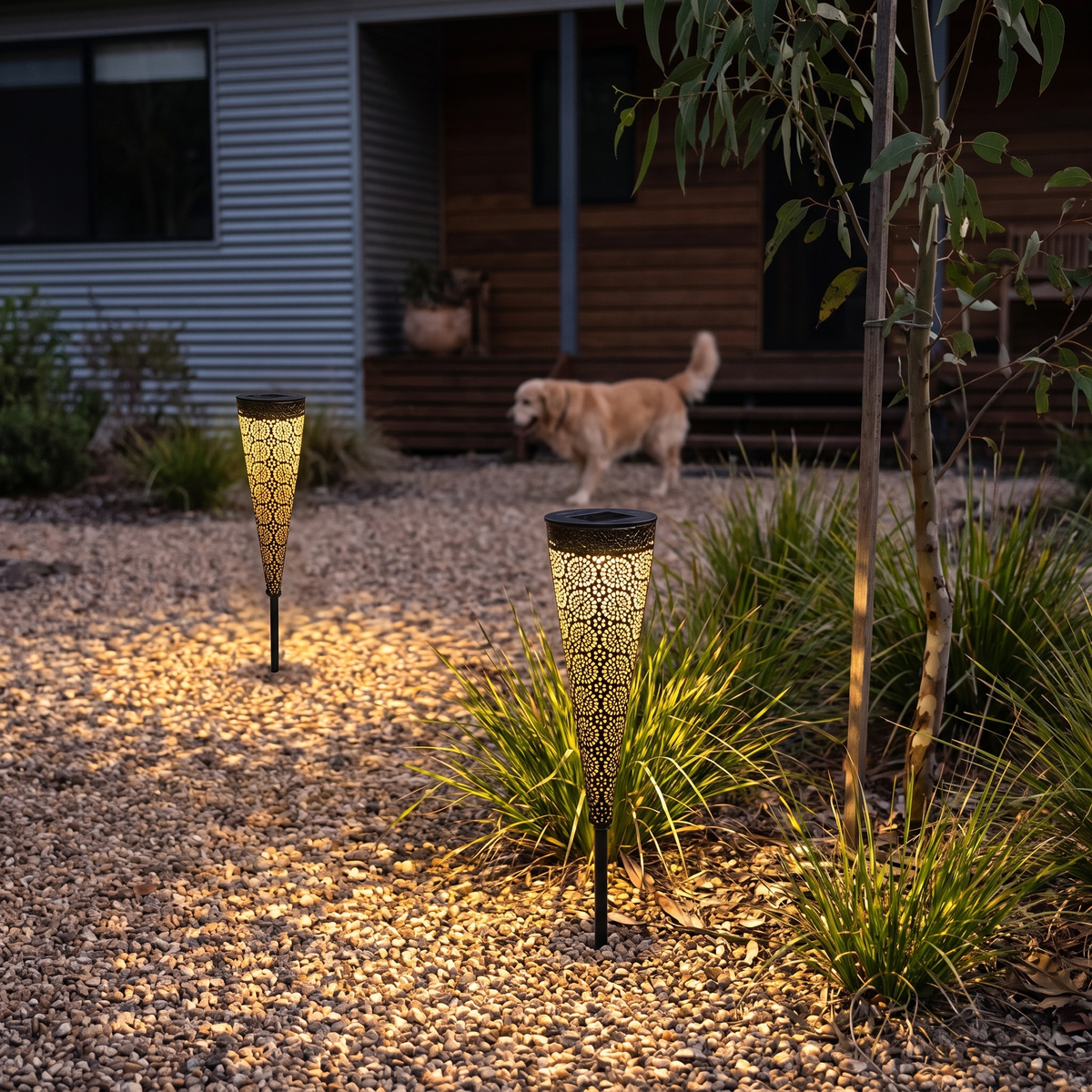Two Bili Solar Garden Lights glowing in a gravel courtyard of a hinterland home at night