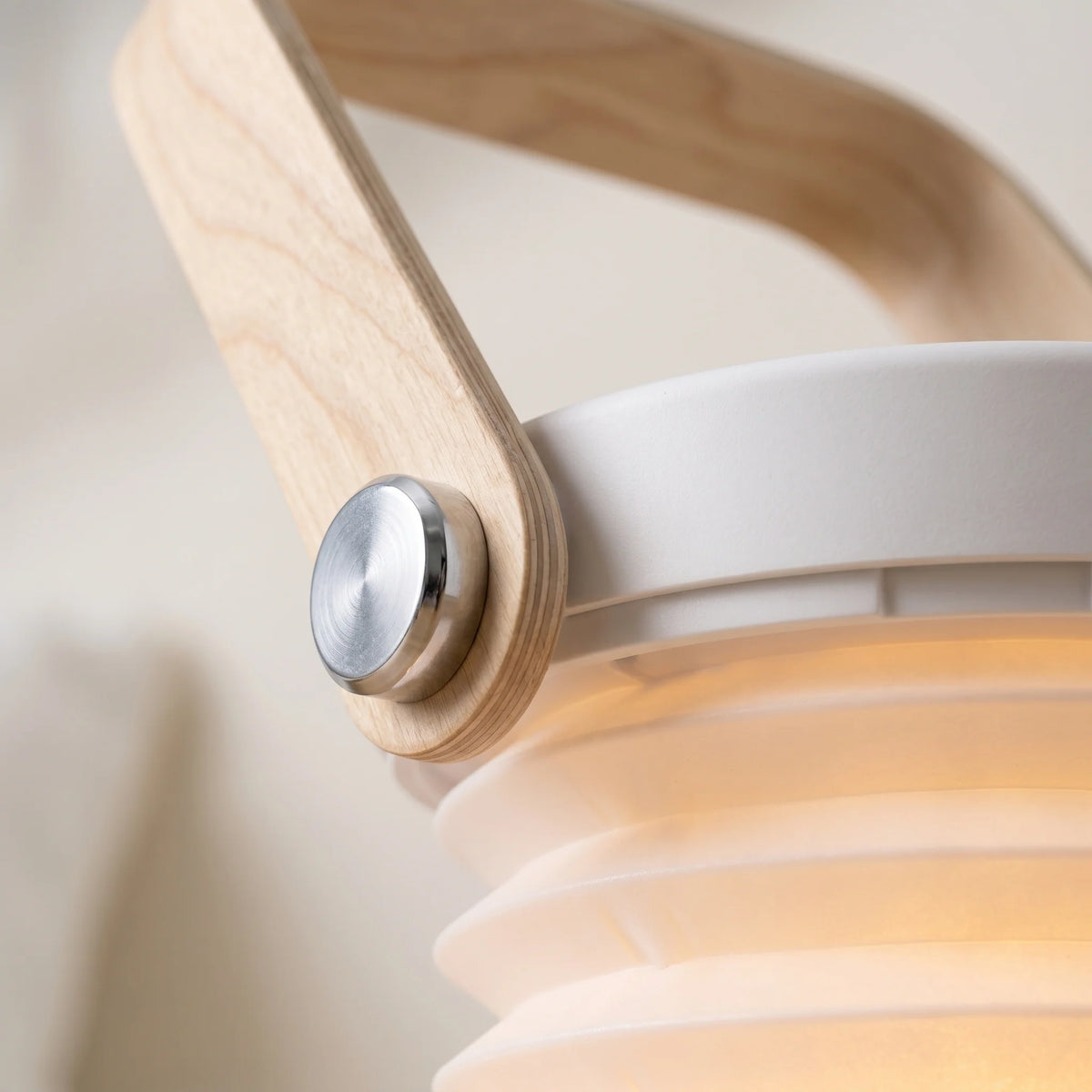 Brae folding travel lantern close-up of the birch wood handle, metal pivot stud and pleated shade