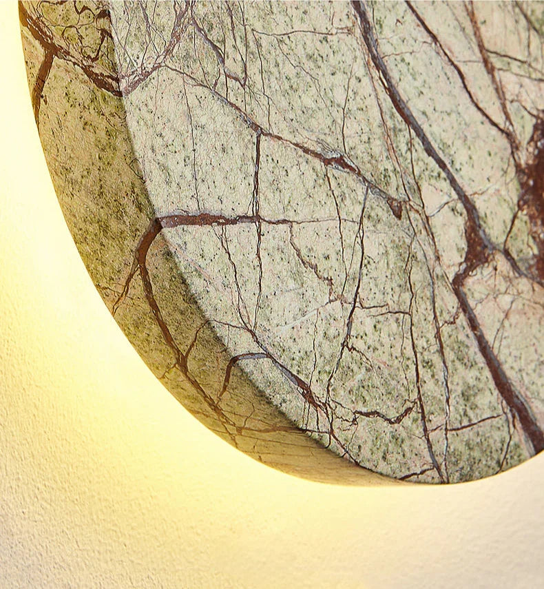 Bronte circular marble wall sconce mounted on a wall