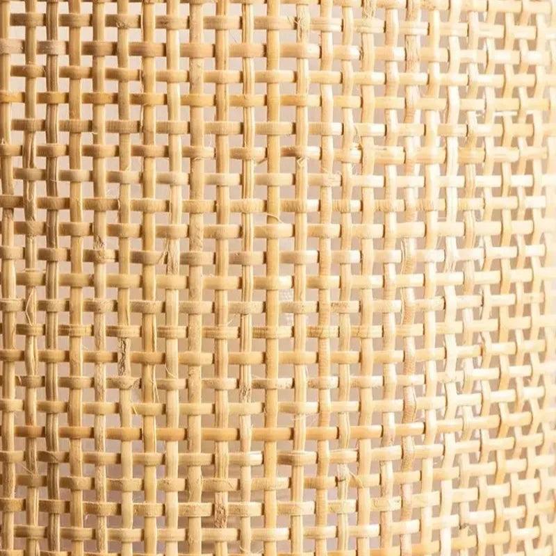 Close-up of the Canggu wall lamp's woven wicker texture with warm LED glow