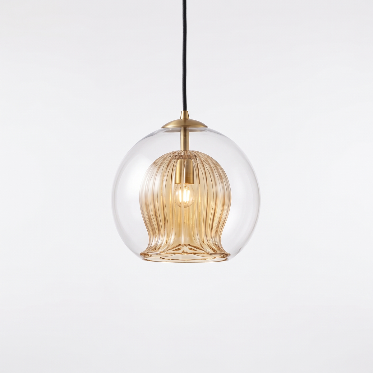 Capri amber glass pendant light with clear outer globe and brass cap on a white background