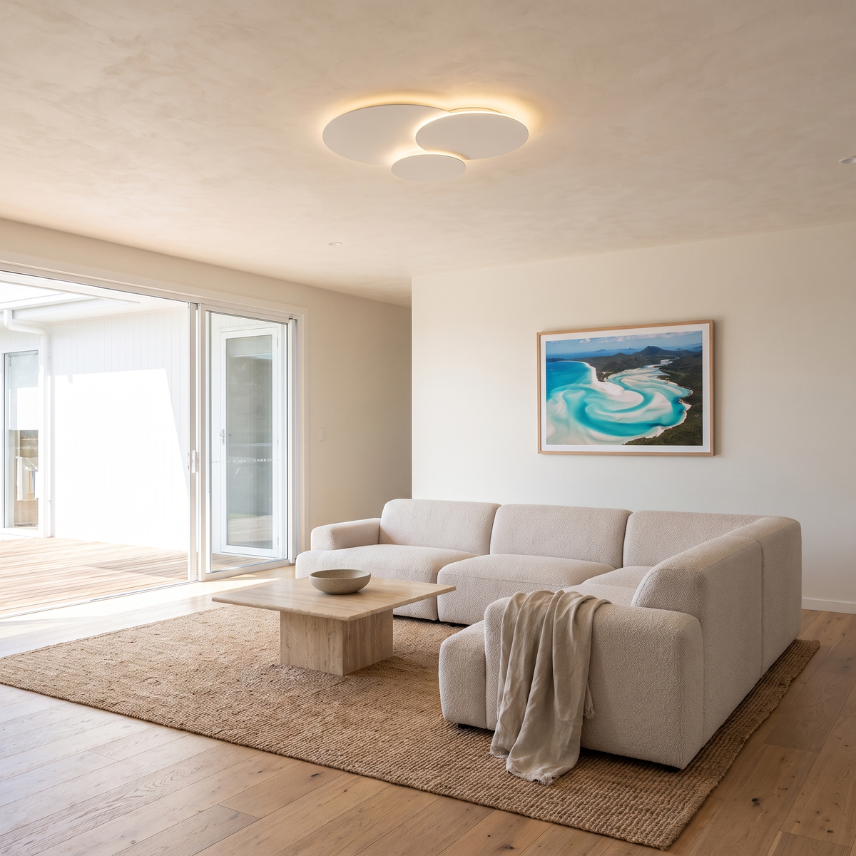 Cloey cloud disc LED ceiling light in an open-plan living room with a boucle modular sofa