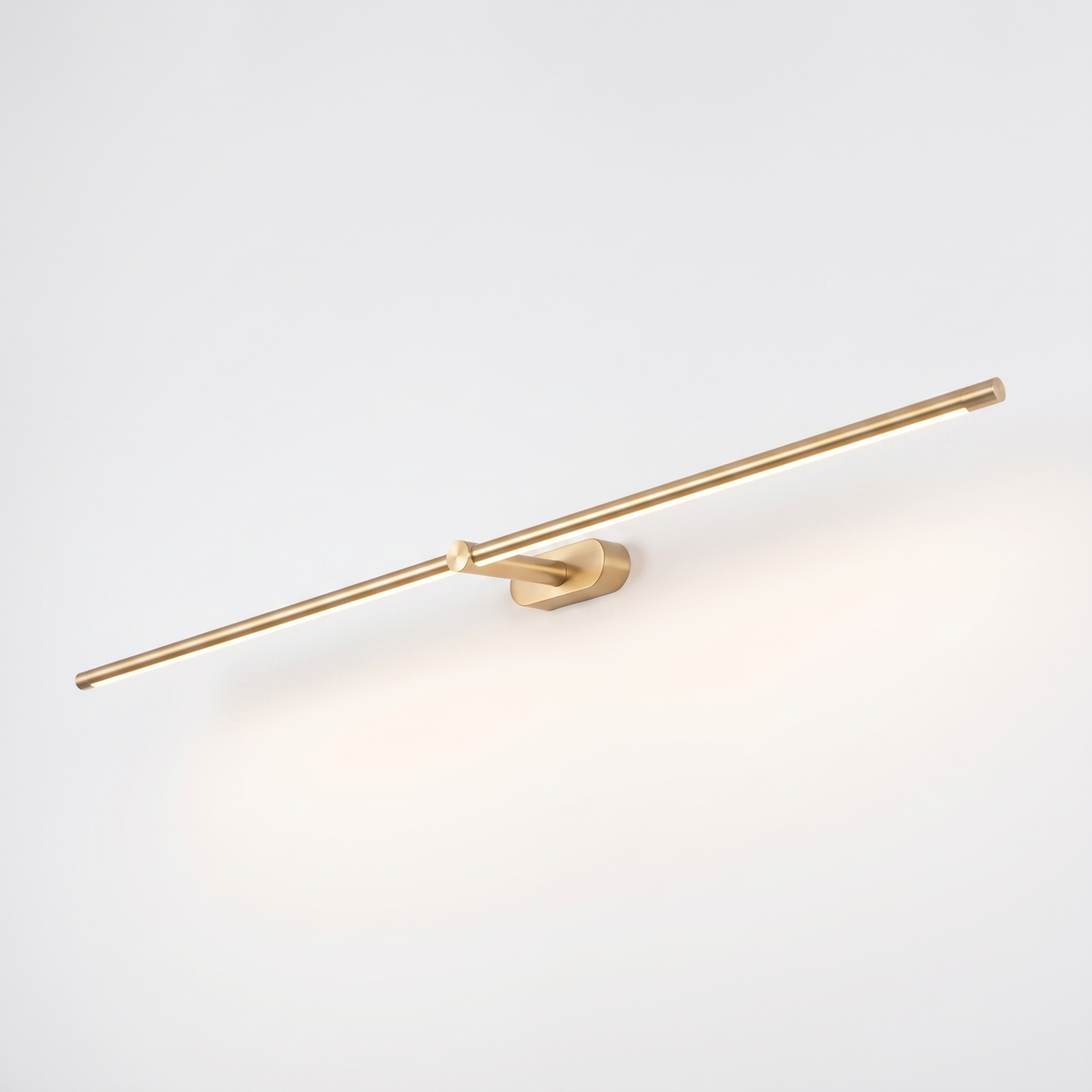 Debi gold linear wall lamp with pivot knuckle and oval wall plate on a plain white background