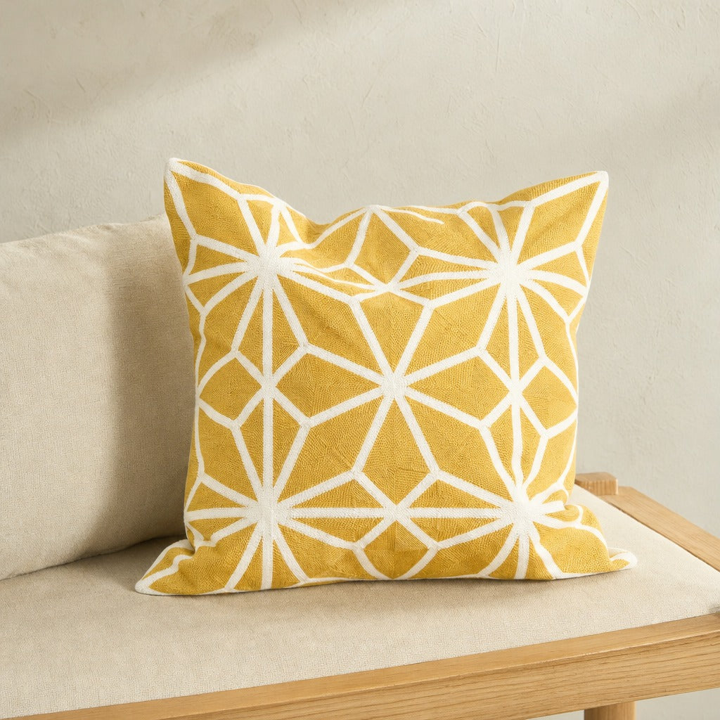 Diamond Tiles mustard cushion cover with a white geometric star pattern on a linen oak bench