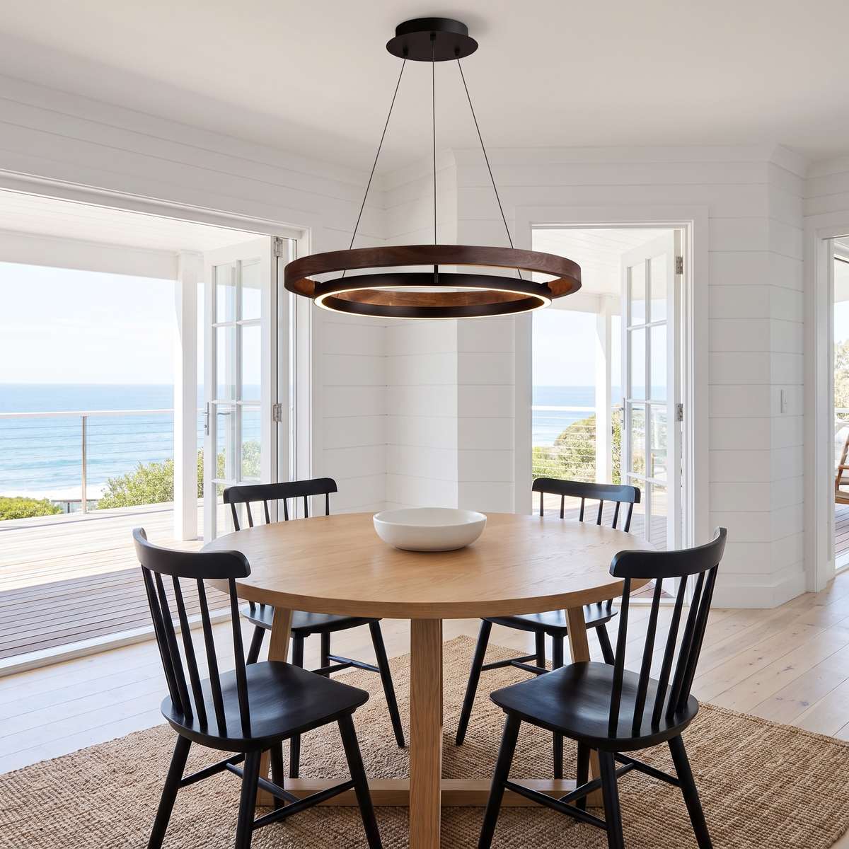 Fesha walnut and black double-ring pendant over a round oak dining table in a beach house