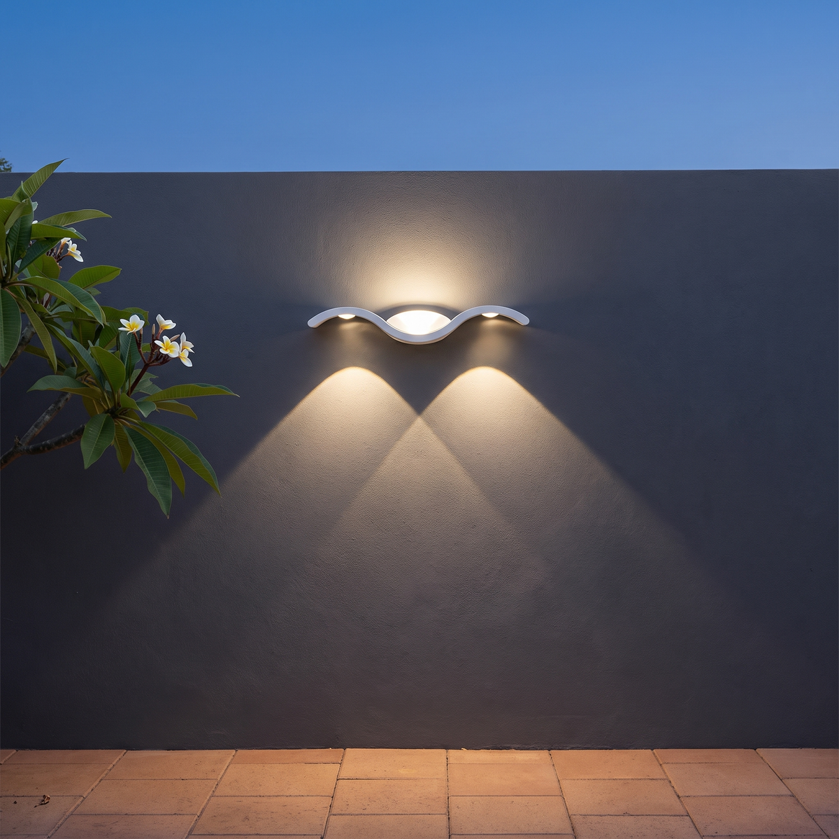 Fly Modern Outdoor Wall Light in white on a charcoal courtyard wall with frangipani at dusk