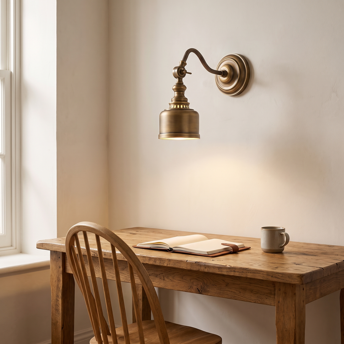 Foster swan neck antique brass wall light above a timber study desk