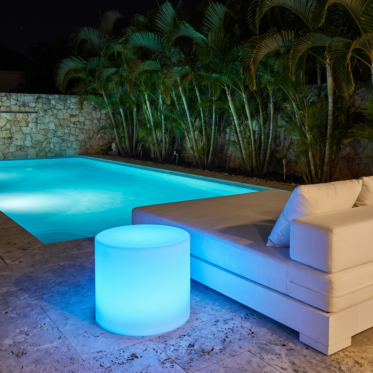 Geri LED outdoor table glowing blue beside a swimming pool at night