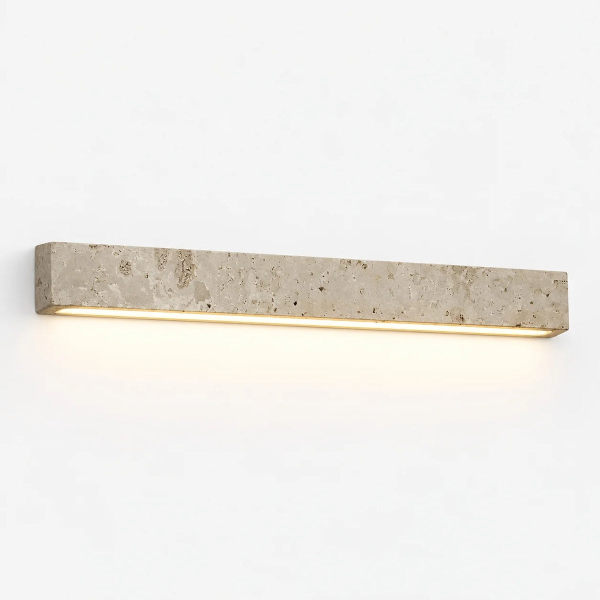 Guru yellow travertine linear wall light glowing downward on a plain white wall