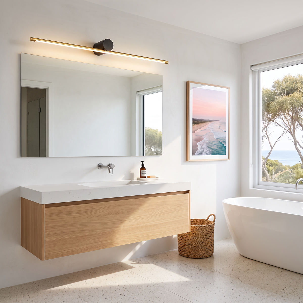 Gold and black Hartog vanity light bar over a wide mirror in a coastal bathroom with a freestanding bath