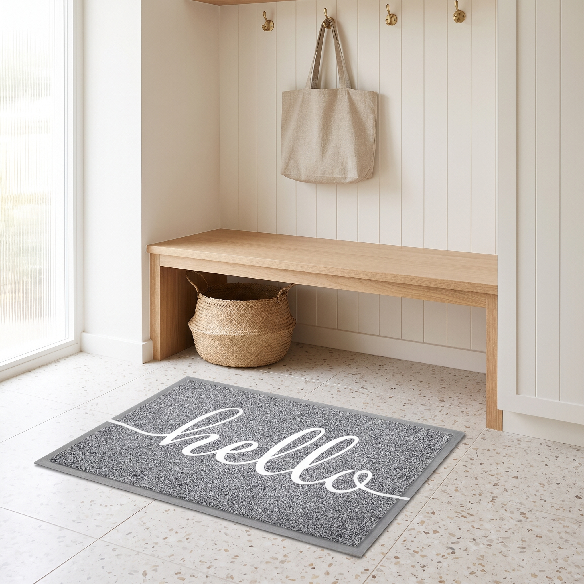 Hello welcome doormat in grey on a terrazzo floor in a coastal mudroom entry