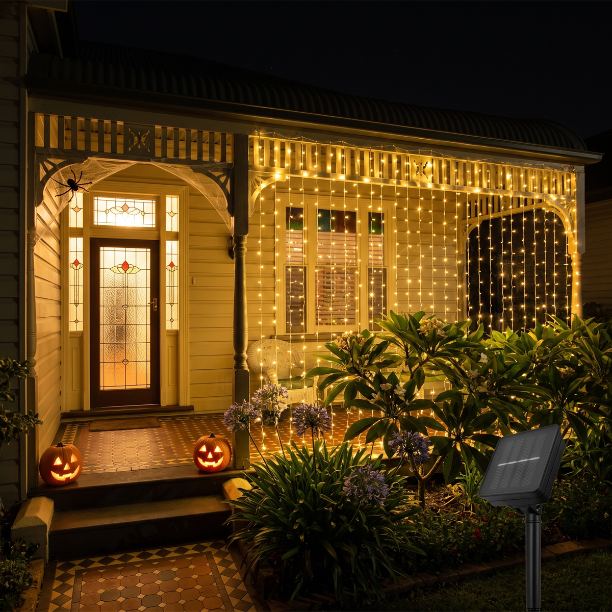 Solar curtain lights hung across an Australian weatherboard cottage verandah at night