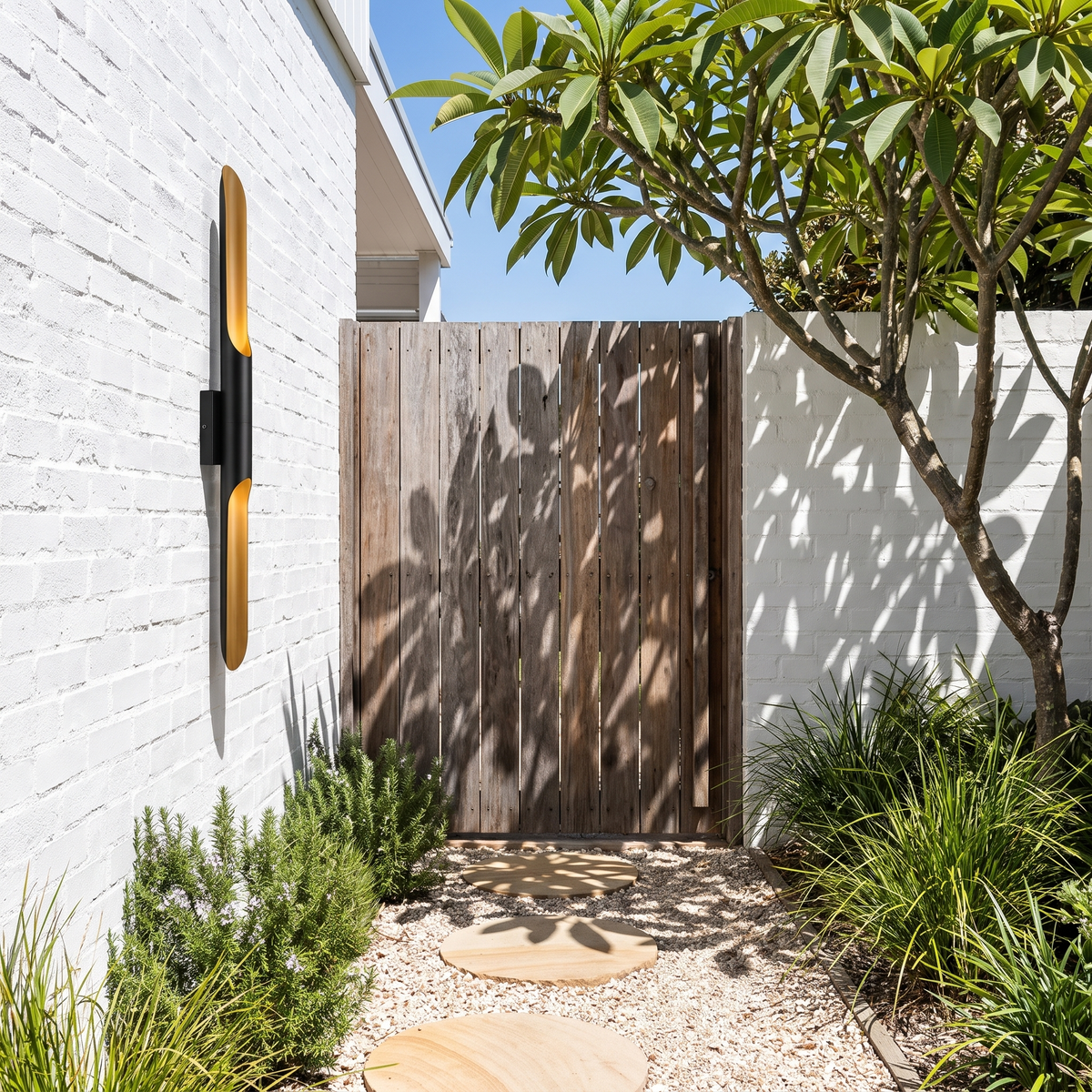 Single-tube Jarra steel wall light on white bagged brick beside a spotted gum gate at midday
