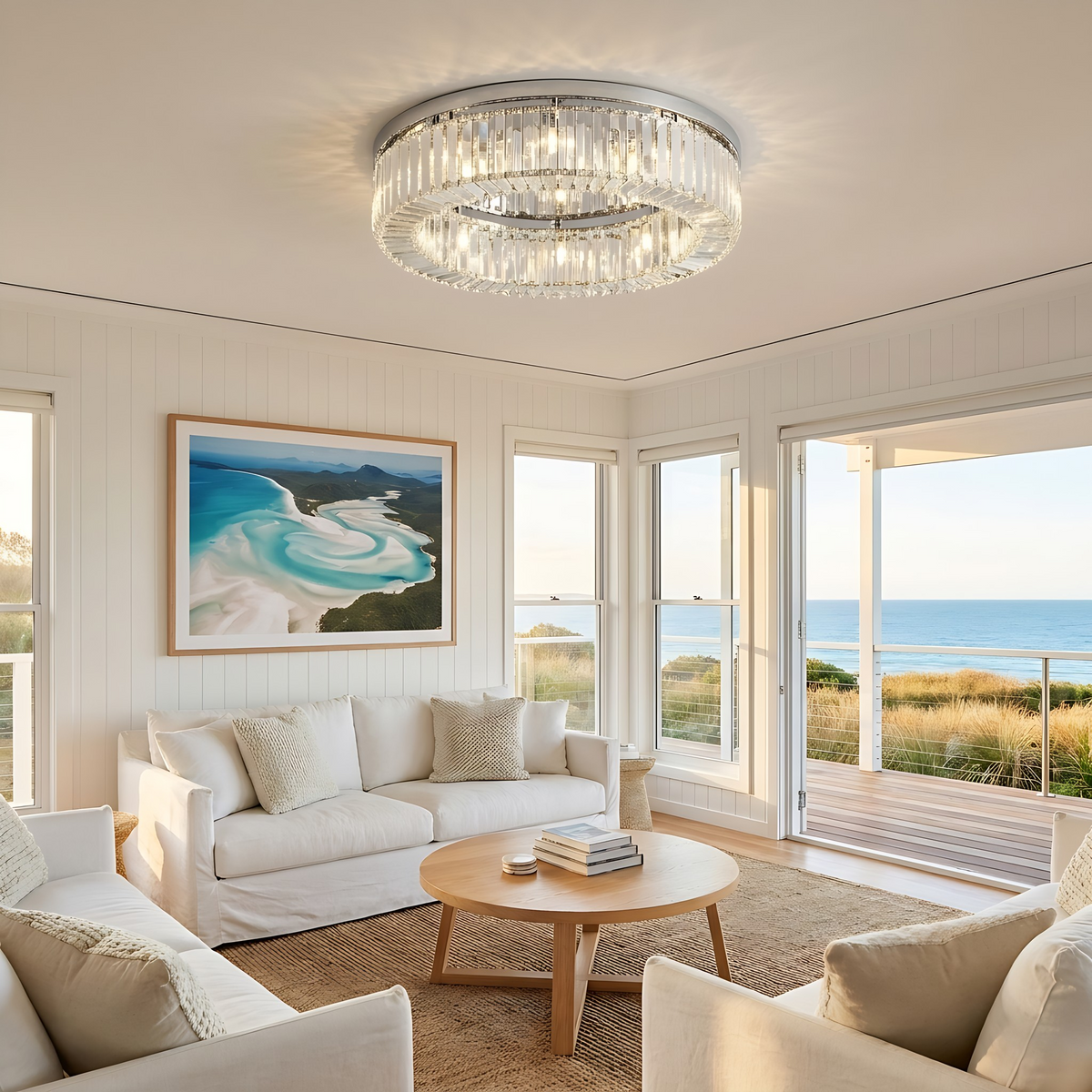 Large chrome Jessi crystal flush mount light in a bright coastal living room with ocean views