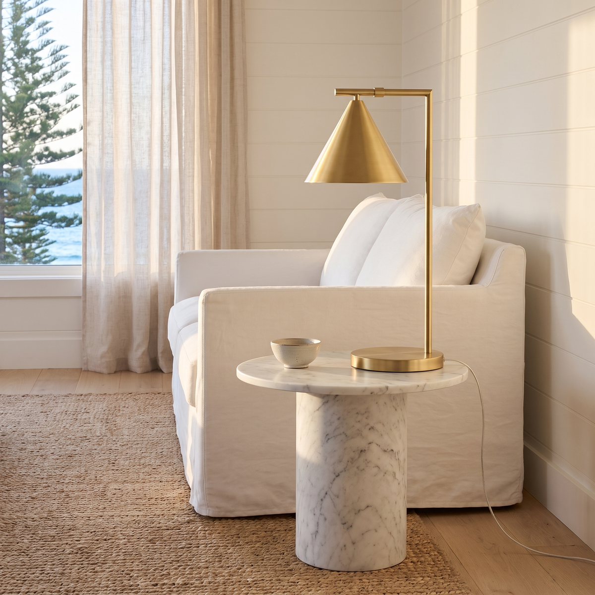 Joey classic brass table lamp on a marble side table in a coastal living room