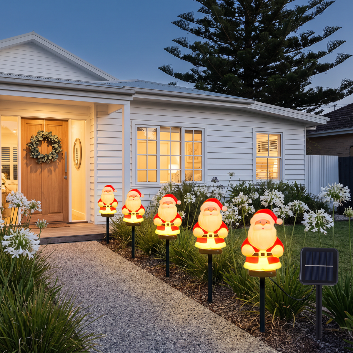Jolly solar Santa garden lights lining a beach house front path at dusk