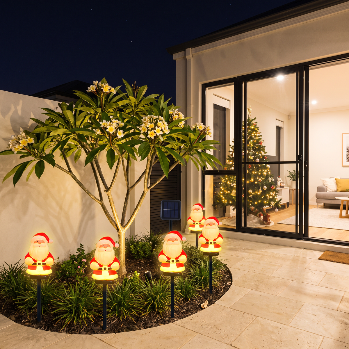 Jolly solar Santa lights around a frangipani in a courtyard garden at night
