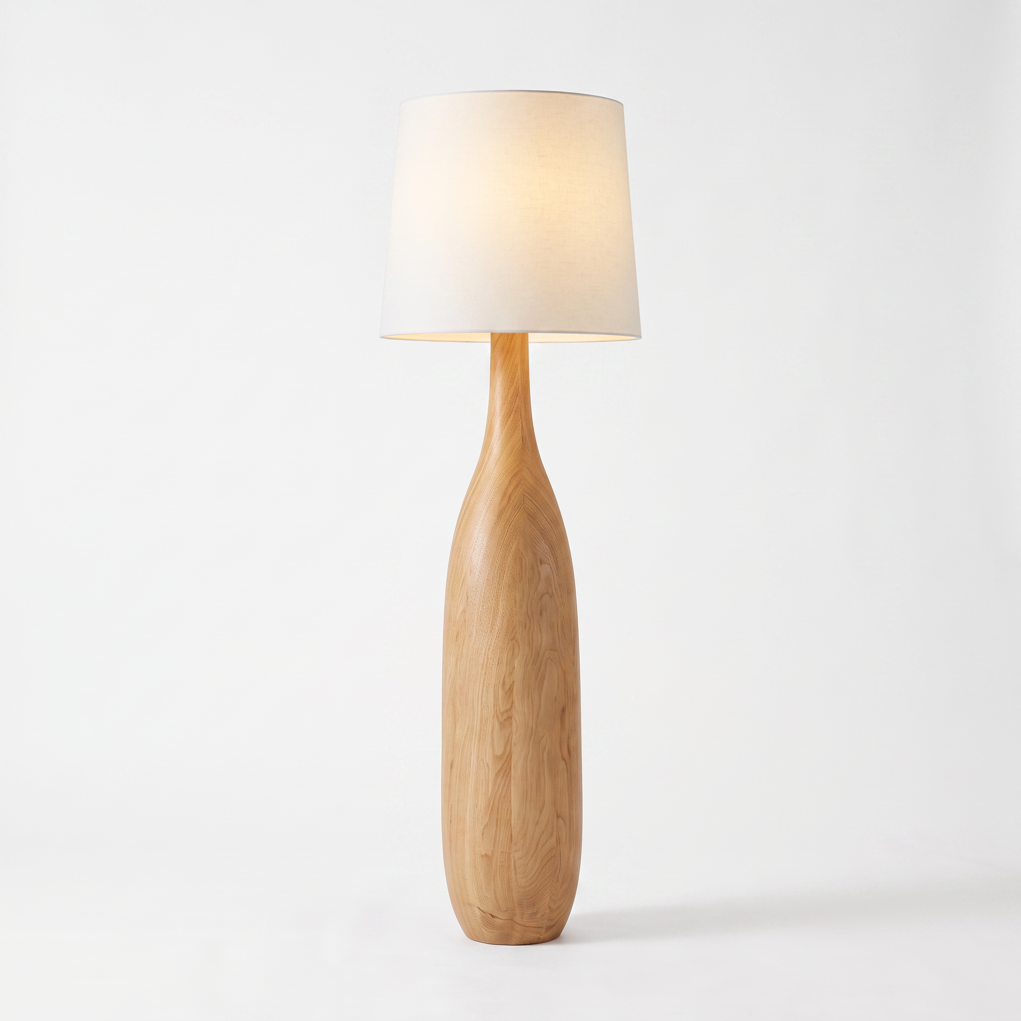 Kiwa sculptural wood base floor lamp with fabric shade on a white studio background