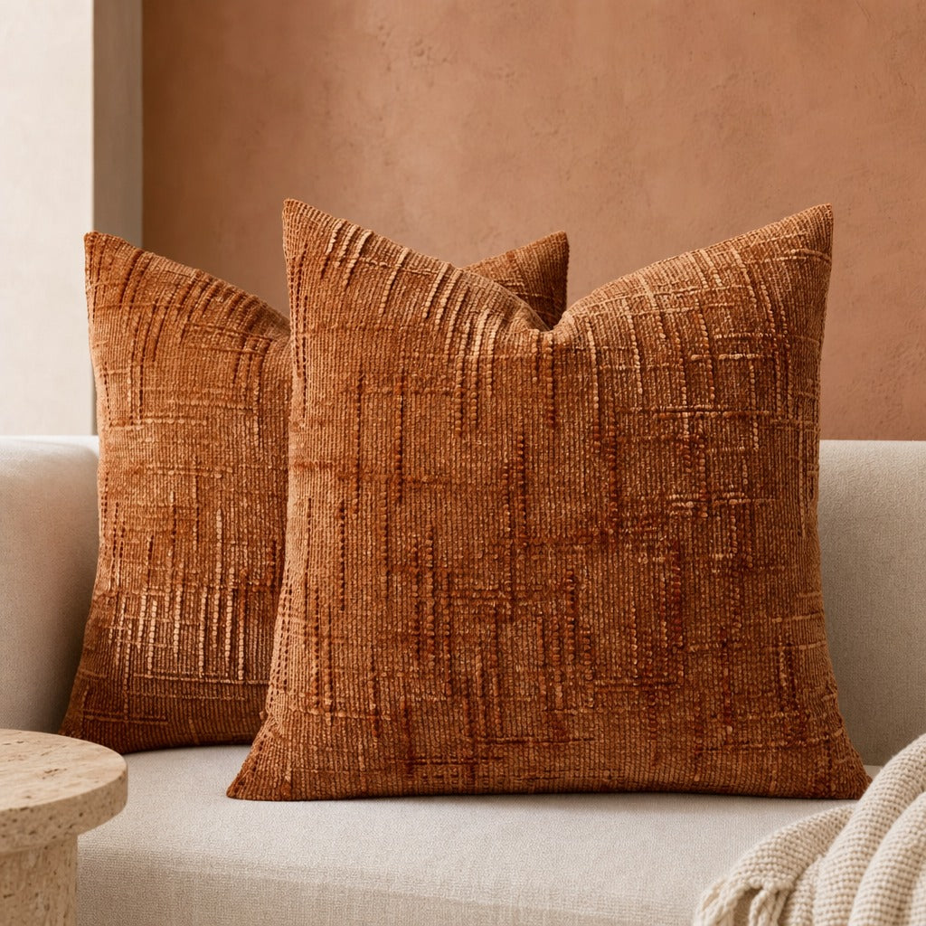 Lucina chenille throw pillows in brown red against a terracotta wall on a cream sofa