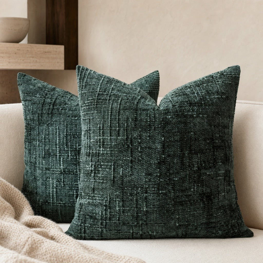 Lucina chenille throw pillows in dark green on a cream sofa with a draped throw